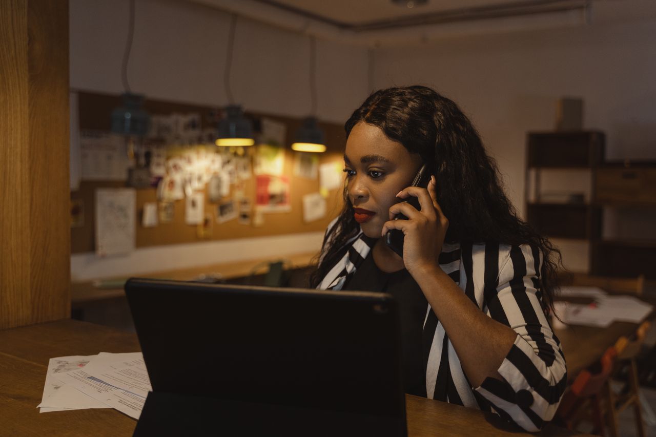 Portage salarial business developer : femme au téléphone devant une tablette au bureau