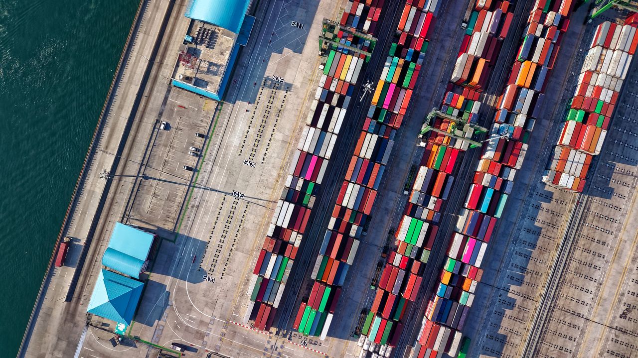 Portage salarial import-export : vue aérienne de conteneurs colorés sur un terminal portuaire