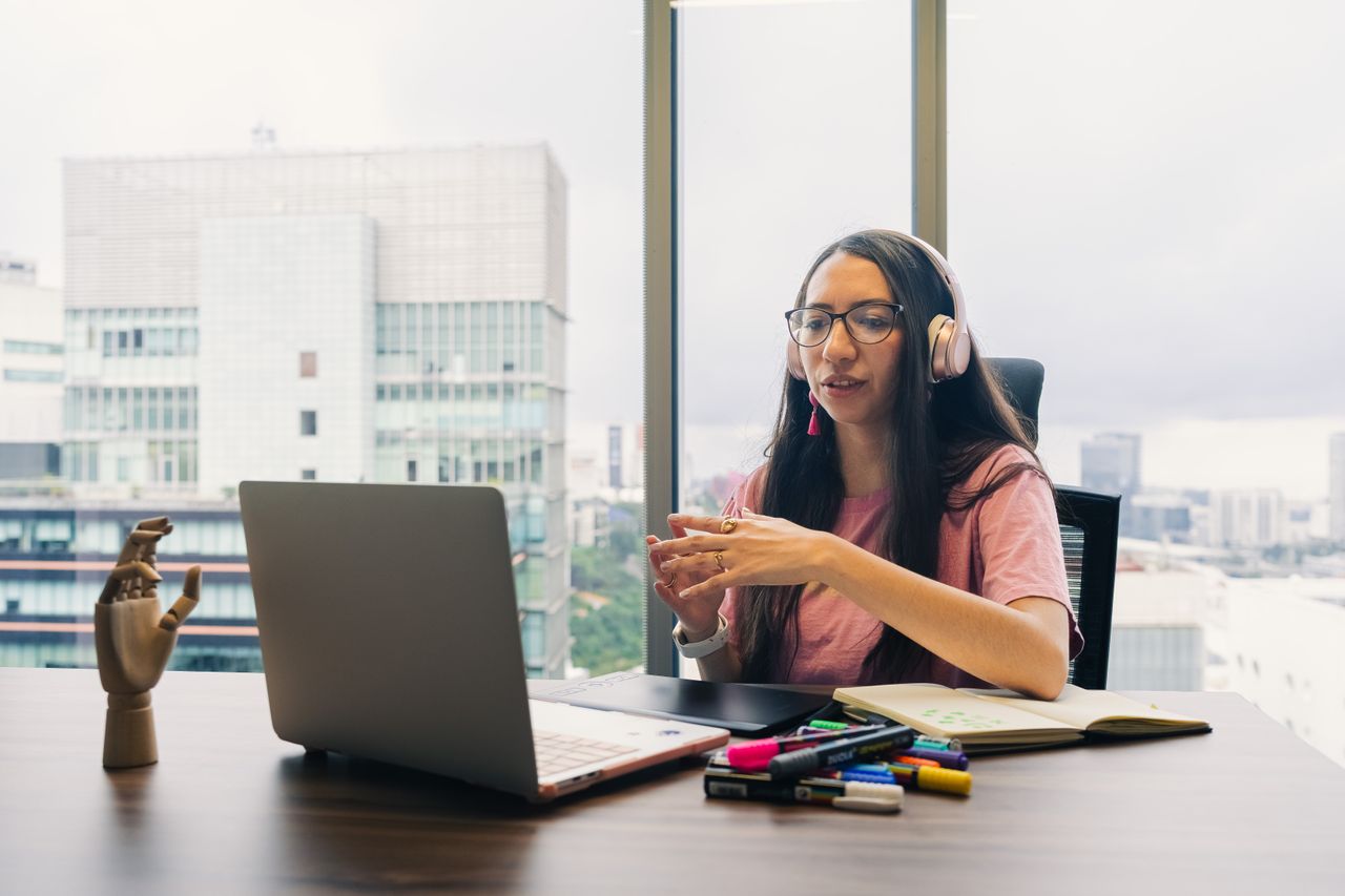 Portage salarial customer success manager : femme avec casque en visioconférence devant son ordinateur
