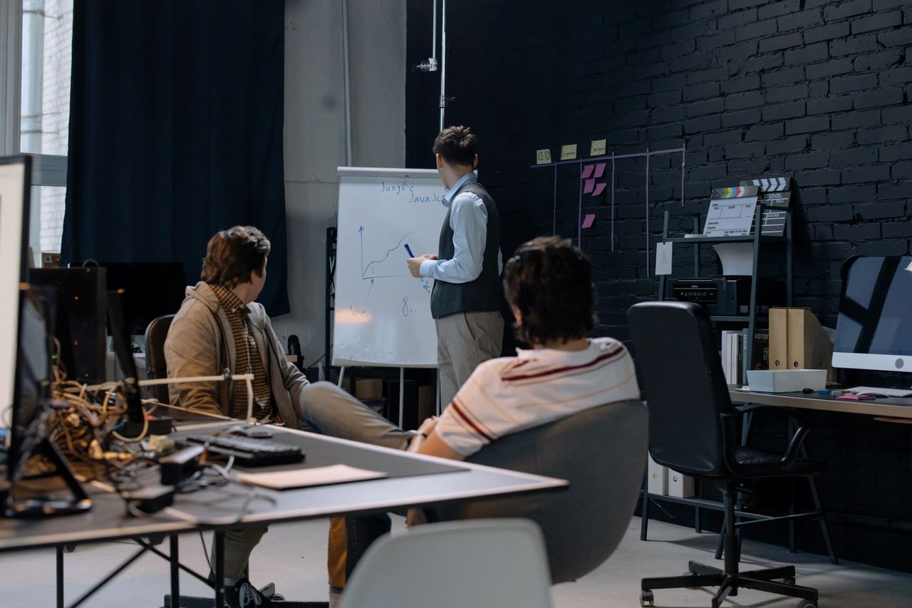 Portage salarial formateur commercial : formateur au tableau blanc face à deux participants