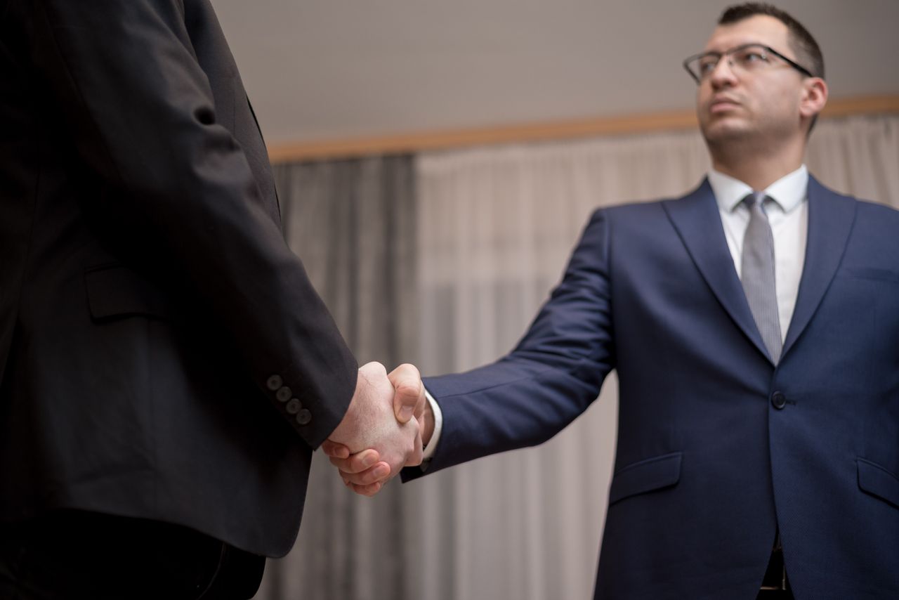 Portage salarial key account manager : poignée de main entre deux hommes en costume